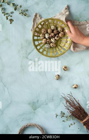 Wachtel Ostereier, natürliche Frühlingsdekorationen und Eukalyptuszweige. Flach auf Marmortisch liegend, Kopierraum. Stockfoto