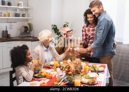 Aufgeregt multiethnischen Familie klirren Weingläser während der Feier Danksagung Tag Stockfoto