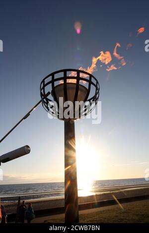 Prestwick, Ayrshire, Schottland Großbritannien 05. Juni 2012 Beleuchtung eines Leuchtfeuers am Prestwick Beach zur Feier der Olympischen Spiele 2012 mit der Isle of Arran und dem Firth of Clyde Ground ging die Sonne unter, so dass es einen Lichtreflexe vom sunlight.beacons. Oder Feuerfeuer, waren Feuer, die angezündet wurden, um die lokalen Menschen vor dem Herannahen eines Feindes zu warnen. Sie lagen auf hohen Hügeln, in der Regel als Teil eines defensiven Signalsystems oder einer Kette, die sich von der Küste bis ins Landesinnere erstreckte. Das Signal wurde durch Rauch am Tag und Licht in der Nacht gegeben. Stockfoto