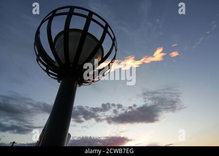 Prestwick, Ayrshire, Schottland Großbritannien 05. Juni 2012 Beleuchtung eines Leuchtfeuers am Prestwick Beach zur Feier der Olympischen Spiele 2012 mit der Isle of Arran und dem Firth of Clyde Ground ging die Sonne unter, so dass es einen Lichtreflexe vom sunlight.beacons. Oder Feuerfeuer, waren Feuer, die angezündet wurden, um die lokalen Menschen vor dem Herannahen eines Feindes zu warnen. Sie lagen auf hohen Hügeln, in der Regel als Teil eines defensiven Signalsystems oder einer Kette, die sich von der Küste bis ins Landesinnere erstreckte. Das Signal wurde durch Rauch am Tag und Licht in der Nacht gegeben. Stockfoto