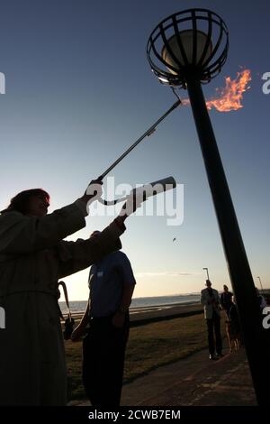 Prestwick, Ayrshire, Schottland Großbritannien 05. Juni 2012 Beleuchtung eines Leuchtfeuers am Prestwick Beach zur Feier der Olympischen Spiele 2012 mit der Isle of Arran und dem Firth of Clyde Ground ging die Sonne unter, so dass es einen Lichtreflexe vom sunlight.beacons. Oder Feuerfeuer, waren Feuer, die angezündet wurden, um die lokalen Menschen vor dem Herannahen eines Feindes zu warnen. Sie lagen auf hohen Hügeln, in der Regel als Teil eines defensiven Signalsystems oder einer Kette, die sich von der Küste bis ins Landesinnere erstreckte. Das Signal wurde durch Rauch am Tag und Licht in der Nacht gegeben. Stockfoto