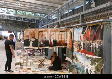 Porträts von Karl Marx, Friedrich Engels, Wladimir Lenin und Joseph Stalin in einem chinesischen Markt. Diese beliebten Symbole des Kommunismus sitzen neben einem Porträt des großen Vorsitzenden Mao Stockfoto