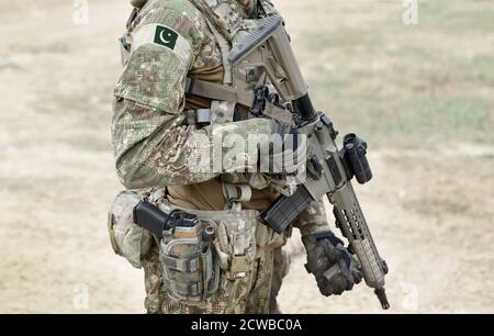Soldat mit Maschinengewehr und Flagge Pakistans auf Militäruniform. Collage. Stockfoto