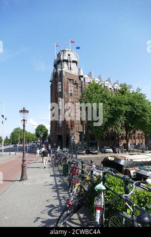 Das Grand Hotel Amrath, Amsterdam; ehemals das Schifffahrtshaus (Scheepvaarthuis). Das erste wahre Beispiel der Amsterdamer Schule, ein Stil, der von "expressiver Dynamik, üppiger Ornamentik und farbenfrohen Verzierungen" geprägt ist. Es wurde an der Stelle errichtet, wo Cornelis Houtmans erste Reise nach Ostindien 1595 begonnen hatte. Der erste Teil wurde 1913 - 1916 (während des Ersten Weltkrieges) gebaut, der zweite Teil wurde 1926 - 1928 gebaut. Stockfoto