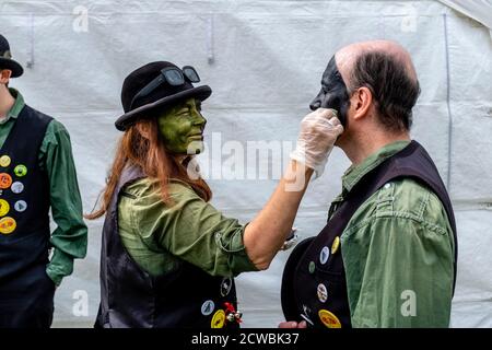 Eine Gruppe von Morris-Tänzern, die ihr Make-up vor dem Auftritt im Hartfield Village Fete, Hartfield, East Sussex, Großbritannien, anwenden. Stockfoto