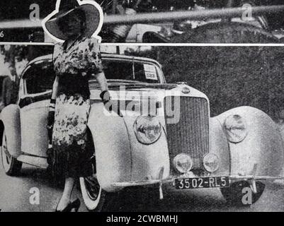 Schwarz-Weiß-Foto in Bezug auf die Leistungen in der Automobilherstellung im Jahr 1938; ein Wettbewerb der Luxus-Automobile. Eine gut gekleidete Frau steht neben einem neuen Auto. Stockfoto