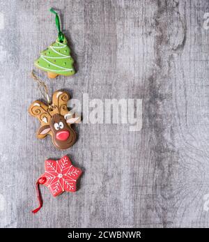 Weihnachten Handgefertigte gemusterte Lebkuchen als Weihnachtsbaum, Rentier Rudolph und Schneeflocke Formen über weiße Holzoberfläche. Mit Kopierplatz rechts Stockfoto