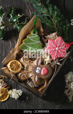 Weihnachten handgefertigten Lebkuchen als Weihnachtsbaum, Rentier Rudolph und Schneeflocke Formen in Holzkiste über alten Holztisch, durch f eingerichtet gemusterten Stockfoto