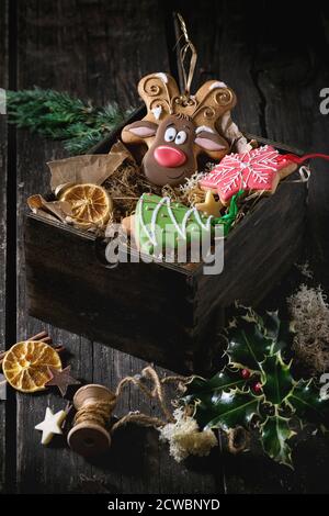 Weihnachten handgefertigten Lebkuchen als Weihnachtsbaum, Rentier Rudolph und Schneeflocke Formen in Holzkiste über alten Holztisch, durch h eingerichtet gemusterten Stockfoto