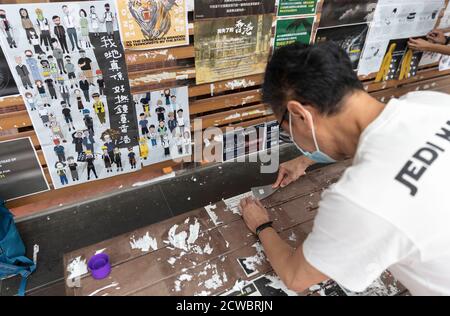 Hongkong, China. September 2020. Ein Mann, der die Lennon-Mauer aufräumte, die an der Hong Kong University sabotiert wurde.etwa 30 Außenseiter, die in die Universität gingen und die Plakate an vier Lennon-Wänden niederrissen, waren mit Unterstützungsbotschaften für Demonstranten bedeckt. Die Sicherheitsleute wurden nicht gesehen, wie sie die Aktion der Gruppe aufhielten. Es war das zweite Mal, dass die Lennon-Mauern auf dem HKU-Campus seit Juli dieses Jahres verwüstet wurden. Kredit: SOPA Images Limited/Alamy Live Nachrichten Stockfoto