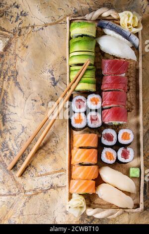 Sushi set Nigiri und Rollen auf Ton Platte serviert mit Stäbchen auf der Steinoberfläche. Flach zu legen. Stockfoto