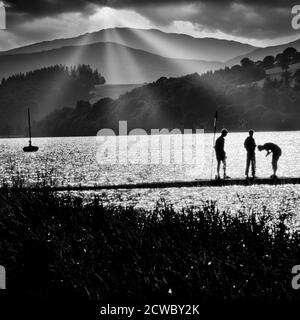 Silhouette von drei Jungen Angeln auf Nord-Wales-See sehr Dramatisch Stockfoto