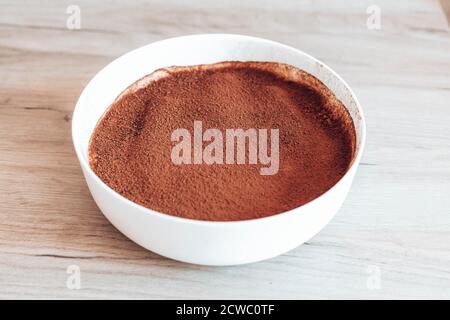 Leckere Tiramisu-Torte mit Sahne und Kakao auf einer Platte Stockfoto