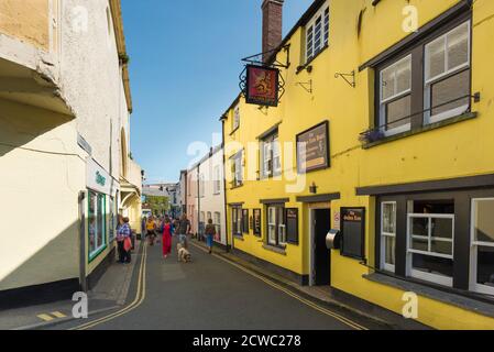 Padstow Stadt, im Sommer sehen Sie die Menschen, die entlang der Lanadwell Street im Hafengebiet von Padstow spazieren, mit dem Golden Lion Pub rechts, Cornwall UK Stockfoto