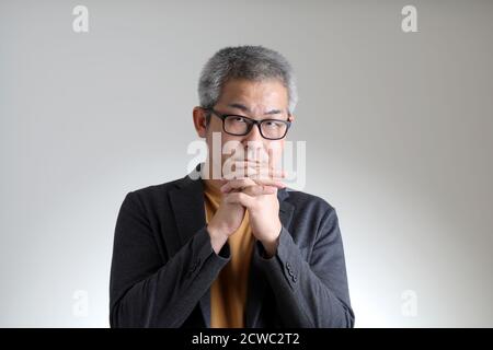 Der asiatische Mann in smart casual stehend auf dem weißen Hintergrund. Stockfoto