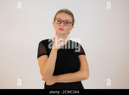 Junge Geschäftsfrau trägt eine Brille, die auf weißem Hintergrund steht und mit dem Finger nach oben zeigt und wütend ist, ohne Geste Stockfoto
