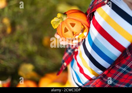 Kinder Hand hält Jack'O Kürbis Lampe, Trick or Treat an Halloween Tag. Konzept für Herbstferien Hintergrund. Stockfoto