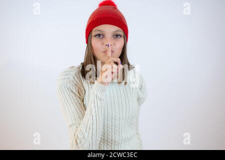 Schöne Mädchen in Winterkleidung tun Stille Geste auf weiß Hintergrund Stockfoto