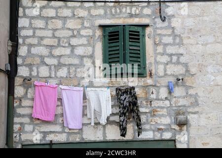 Die Wäsche wird an einem Seil an der Wand getrocknet Stockfoto