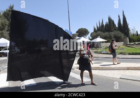 Jerusalem, Israel. September 2020. Ein Israeli hält eine riesige schwarze Flagge bei einer Demonstration während einer landesweiten COVID-19-Sperre gegen den von der Regierung von Ministerpräsident Benjamin Netanjahu vorgeschlagenen Gesetzesentwurf zur Einschränkung von Protesten vor der Knesset, dem Parlament, am Dienstag, den 29. September 2020 in Jerusalem. Der Gesetzentwurf würde Demonstranten verbieten, mehr als einen Kilometer, 0.621 Meilen, von ihren Häusern zu fahren. Foto von Debbie Hill/UPI Kredit: UPI/Alamy Live Nachrichten Stockfoto