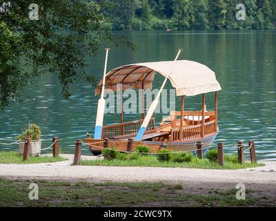 Schönes Holzboot auf dem berühmten Bleder See in Slowenien. Der Bleder See, bekannt für seine Burg und Insel, ist ein beliebtes Reiseziel. Touristenboote sind wir Stockfoto