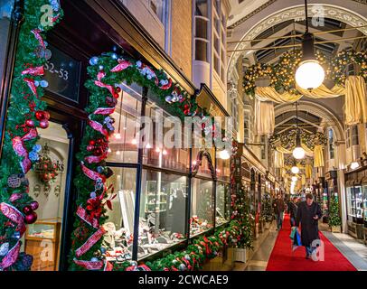 London CHRISTMAS Burlington ‘olde worlde traditionelle Einkaufspassage in Piccadilly mit traditionellen weihnachtlichen Dekorationen und Weihnachtseinkäufern, die in einem überdachten, luxuriösen Einzelhandelsumfeld einkaufen. London UK Stockfoto