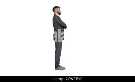 Selbstbewusster Geschäftsmann mit Bart und Mustaschen im Anzug stehend mit gefalteten Händen auf weißem Hintergrund. Stockfoto