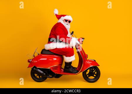 Profil Seitenansicht seiner er schön lustig dick weißhaarig Santa Reiten Motorrad schnelle Geschwindigkeit beeilen Sie sich Rush Verkauf hut Ball fliegen Rennen Rallye isoliert Stockfoto