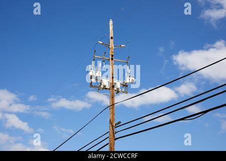 Pfosten und Drähte gegen einen blauen Himmel Stockfoto