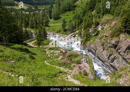 In der Nähe von Cogne, Aostatal, Italien. Kinder auf Exkursion und Annäherung an die Torrente Grand’ Eyvia im Parco Nazionale del Gran Paradiso (Gran para Stockfoto