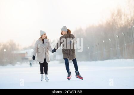 Glückliches junges Paar im sonnigen Winter Natur Eislaufen Stockfoto