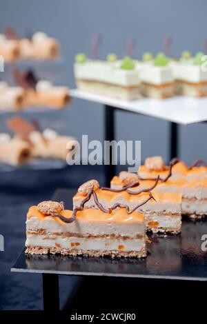 Süßer Desserttisch für Catering und Hochzeiten, Schokoladenkuchen mit Mango und Buttercreme Stockfoto