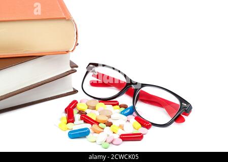 Stapel von Büchern und Pillen, Kapseln isoliert auf weißem Hintergrund. Arzneimittel. Medikamente und Medikamente. Stockfoto