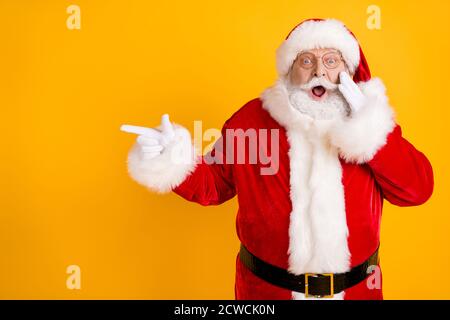 Foto staunte Fett santa claus Point Finger beeindruckt x-Mas Neujahr weihnachten Magie Wunder Anzeigen promo berühren weißen Handschuhe Gesicht schreien Kopfbedeckung tragen Stockfoto