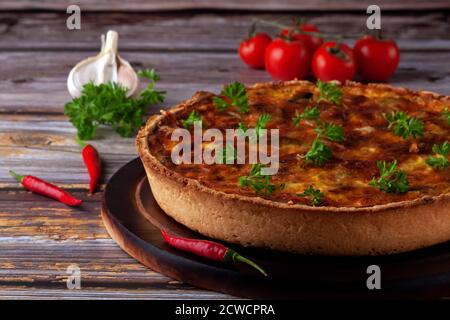 Französische Quiche mit Huhn und Pilzen auf Holzgrund Stockfoto