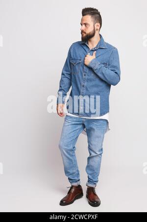 Junger Mann im Denim-Anzug. Schöner Mann in Jeansjacke und Jeans auf weißem Hintergrund. Foto für die Werbung Herren Jeans und Jacken. Konzept für Stockfoto