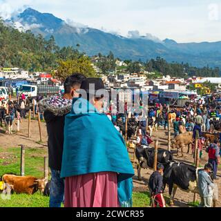 Indigene ecuadorianische Otavalo Frau mit Sohn Blick auf den Tiermarkt von Otavalo mit dem Cotacachi Vulkan im Hintergrund, Ecuador. Stockfoto