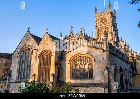 Die Kirche des heiligen Johannes des Täufers aus dem Garten der Erinnerung bei Sonnenaufgang im Herbst. Cirencester, Cotswolds, Gloucestershire, England Stockfoto