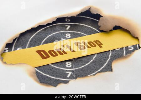 Text nicht aufhören, unter dem verbrannten Papier geschrieben Stockfoto