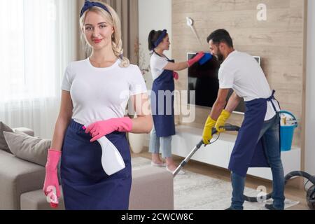 Professionelles Reinigungsservice-Team reinigt Wohnzimmer in modernen Wohnung Stockfoto