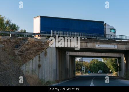 LKW fährt über eine Brücke mit einer Straße darunter Stockfoto