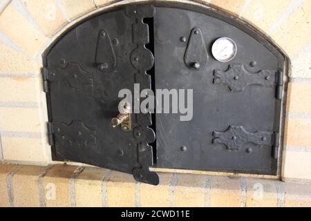 Ein Steinofen ist in der Nähe von Prosek, Prag, Tschechien, zu sehen. Es scheint eine metallische Tür zu haben, mit metallischen Türscharnieren. Stockfoto