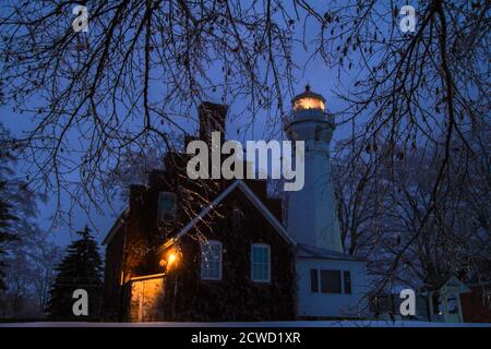 Port Sanilac, Michigan, USA - 12. Dezember 2013: Leuchtfeuer des Port Sanilac Leuchtturms, umgeben von Eiszapfen, in einer kalten Winternacht. Stockfoto