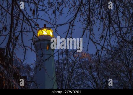 Port Sanilac, Michigan, USA - 12. Dezember 2013: Leuchtfeuer des Port Sanilac Leuchtturms, umgeben von Eiszapfen, in einer kalten Winternacht. Stockfoto