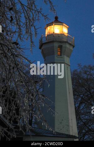 Port Sanilac, Michigan, USA - 12. Dezember 2013: Leuchtfeuer des Port Sanilac Leuchtturms, umgeben von Eiszapfen, in einer kalten Winternacht. Stockfoto