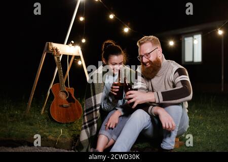 Pärchen haben eine gute Zeit zusammen am Abend Picknick trinken Getränke aus Flaschen Stockfoto