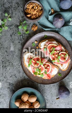 Sandwich mit Ziegenkäse Aufstrich, Prosciutto, Feigen und gehackten Walnüssen Stockfoto