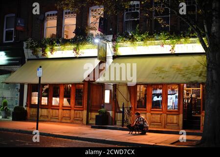 Menschen außerhalb der Abbeyville in Clapham Common in London, um 21:48 Uhr, nach einer Reihe von neuen Beschränkungen, um den Anstieg der Coronavirus-Fälle zu bekämpfen, trat in England. Stockfoto