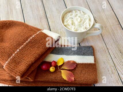Warme Winter-Toque und Schal und leckeren leckeren heißen Kakao Mit Schlagsahne zum Schlucken und Genießen im saisonalen Herbst Tage nach Spaziergängen im Herbst Blätter Stockfoto