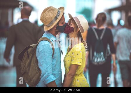 Bild von einem glücklichen Paar im Urlaub. Junger Mann und Frau küssen sich in der Menge Stockfoto